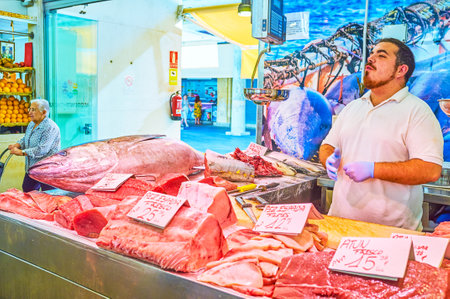 CADIZ, SPAIN - SEPTEMBER 24, 2019: The young tuna fish vendor loud advertises his raw fresh fish in Mercado Central de Abastos, on September 24 in Cadizのeditorial素材