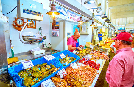 CADIZ, SPAIN - SEPTEMBER 24, 2019: The fishmonger in Mercado Central de Abastos market seafood stall prepares oyster for clients, on September 24 in Cadizのeditorial素材