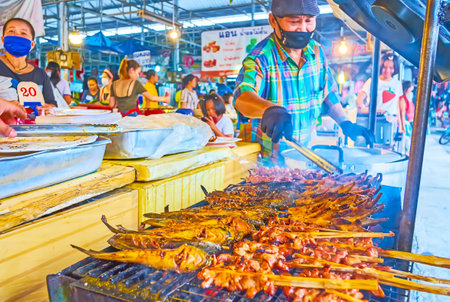 BANGKOK, THAILAND - MAY 13, 2019: The smoky reeky mackerel and pork on skewers, roasting on grill in Talad Saphan Phut market, on May 13 in Bangkokのeditorial素材