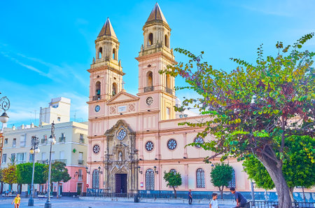 CADIZ, SPAIN - SEPTEMBER 23, 2019: The facade of St Anthony of Padua church with tall bell towers and carved wall, on September 23 in Cadizのeditorial素材