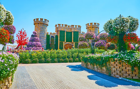 DUBAI, UAE - MARCH 5, 2020: The scenic small castle replica with lush shrubs, sunflowers and petunia in pots around it, Miracle Garden, on March 5 in Dubaiのeditorial素材