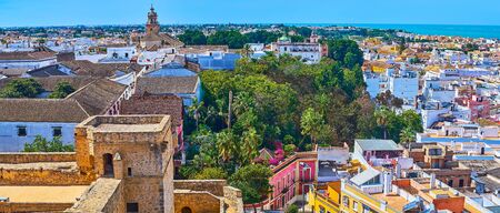 Castillo de Santiago castle overlooks old tile city roofs, large buildings of bodegas wineries, producing fine sherry, living quarters and tall bell towers of churches, Sanlucar, Andalusia, Spainの写真素材