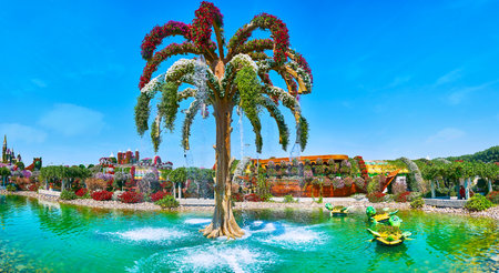 DUBAI, UAE - MARCH 5, 2020: Panoramic view of the pond of Miracle Garden with a palm tree-shaped fountain and sculptures of turtles, serving as the flower pots, on March 5 in Dubaiのeditorial素材