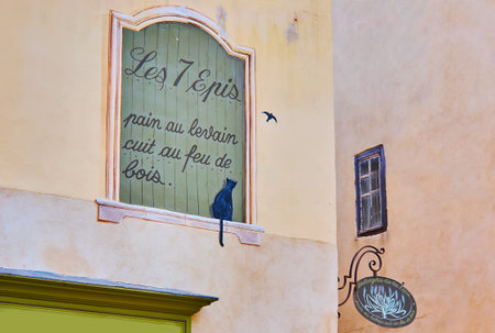 TARASCON, FRANCE - MAY 5, 2013: The decorative painted window with black cat, watching a bird, on the facade of Boulangerie Les 7 Epis (bakery), on May 5 in Tarasconのeditorial素材