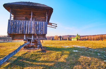 The wide green meadow from behind the old timber windmill, Pyrohiv Skansen, Kyiv, Ukraineのeditorial素材