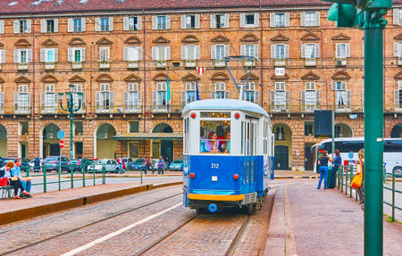 TURIN, ITALY - May 9, 2012: The blue vintage tram rides along the Piazza Castello with a brick building of Prefecture of Turin, seen in the background, on May 9 in Turinのeditorial素材