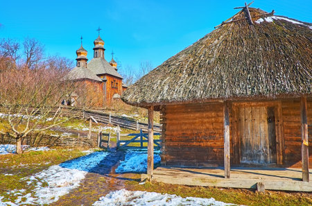 The grounds of Dnieper Ukraine architecture with a view of the timber barn and the St Michael Church behind it, Pyrohiv Skansen, Kyiv, Ukraineのeditorial素材
