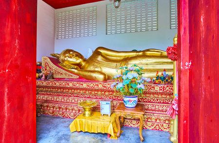 LAMHPUN, THAILAND - MAY 8, 2019: The gilt Reclining Buddha Image in the shrine of  Wat Phra That Hariphunchai Temple, on May 8 in Lamphunのeditorial素材