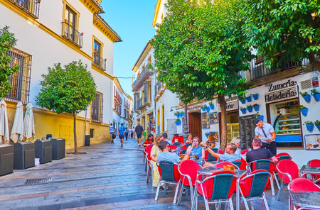 CORDOBA, SPAIN - SEPTEMBER 30, 2019: The Plaza Agrupacion de Cofradias boasts cozy outdoor cafes, hidden in shade of the orange trees, on September 30 in Cordobaのeditorial素材