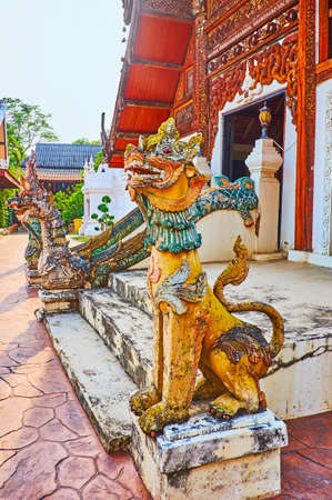 The Singha Lion and Naga serpent sculptures at the Ubosot of Wat Pratu Pong, Lampang, Thailand