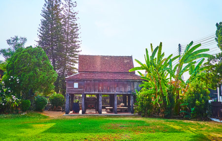The vintage stilt house of Ban Sao Nuk complex with a carriage, parked between the stilts, Lampang, Thailandのeditorial素材