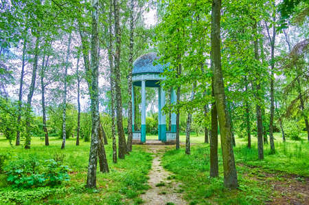 The lush green trees and the vintage wooden rotonda amid the greenery, Pereiaslav Scansen, Ukraineの写真素材