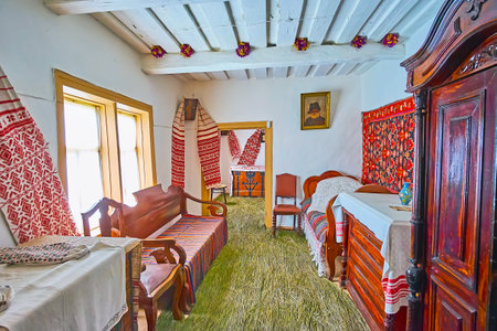 PEREIASLAV, UKRAINE - MAY 22, 2021: The bedroom of the rich peasant's hata house with wooden furniture, Pereiaslav Scansen, on May 22 in Pereiaslavのeditorial素材