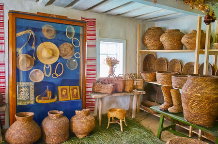 PEREIASLAV, UKRAINE - MAY 22, 2021: Interior of the grain grower's workshop with eicker straw baskets, boots, urns, bowls, hats and other items, Pereiaslav Scansen, on May 22 in Pereiaslavのeditorial素材