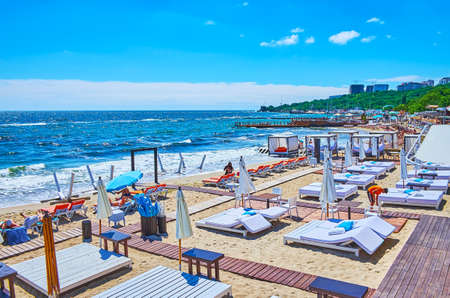 The rows of the sunbeds and sunshades on the sand shore of Otrada Beach, Black Sea, Odessa, Ukraineの写真素材