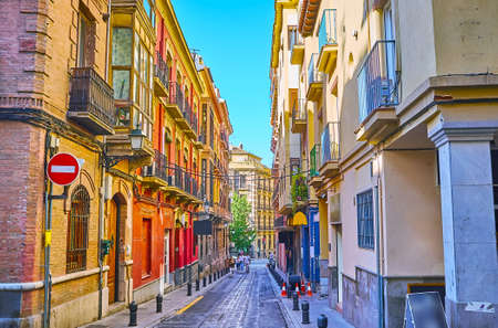 The narrow Azacayas street of Albaicin is lined with tall colorful houses, Granada, Spainの写真素材