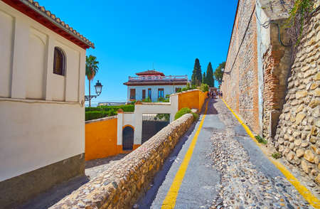 The narrow hilly San Agustina Lane, lined with stone walls and old houses, Albaicin, Granada, Spainの写真素材