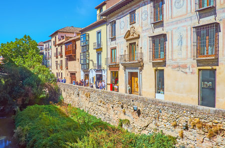 GRANADA, SPAIN - SEPTEMBER 27, 2019: The tall stone banks of Darro River and medieval mansions along Carrera del Darro street, on September 27 in Granadaのeditorial素材