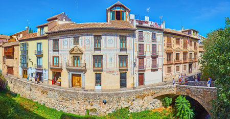 GRANADA, SPAIN - SEPTEMBER 27, 2019: Panorama of historic edifices, Espinosa Bridge, palace, decorated with frescoes and narrow Carrera del Darro street, on September 27 in Granadaのeditorial素材