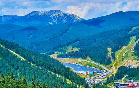 Enjoy the scenic aerial view of the Molodist (Youth) Lake, spruce forests and the gentle slopes of Gorgany Mountain Range, Bukovel, Carpathians, Ukraineの写真素材