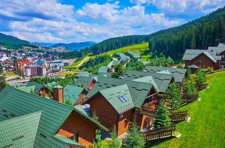Enjoy the scenic mountain landscape with modern wooden houses in the foreground, Bukovel, Carpathians, Ukraineの写真素材