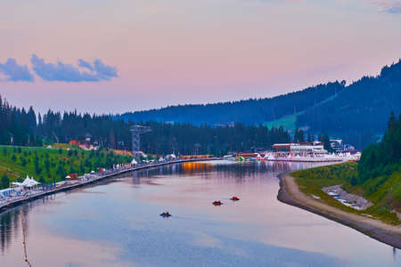 The pleasant evening on the scenic mountain Molodist (Youth) Lake, reflecting the purple sky with blue clouds, Bukovel, Carpathians, Ukraineの写真素材