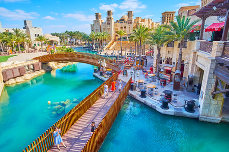 DUBAI, UAE - MARCH 4, 2020: The scenic wooden footbridges over the canals and beautiful restaurants along the bank of Souk Madinat Jumeirah market, on March 4 in Dubai, UAEのeditorial素材