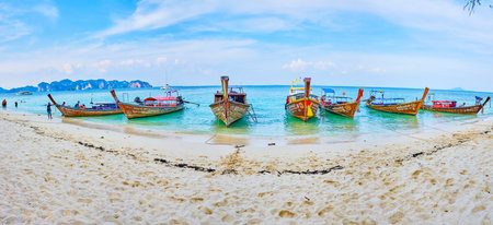 AO NANG, THAILAND - APRIL 26, 2019: The scenic wooden longtail boats are rocking on the tide waves at the sand shore of Koh Poda Island, popular among the holidaymakers, on April 26 in Ao Nangのeditorial素材