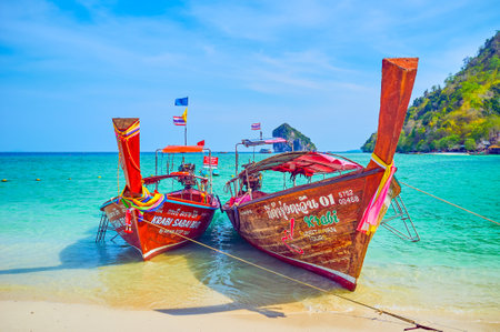The couple of longtail boats are bobbing on the waves, moored at the shore of Koh Mor Island in Ao Nang, Thailandのeditorial素材