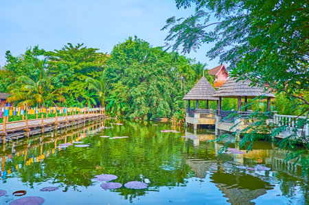 Panorama of the garden of Wat Chetlin temple with a lake, shady pavilions, bamboo bridge and lush greenery, Chiang Mai, Thailandのeditorial素材