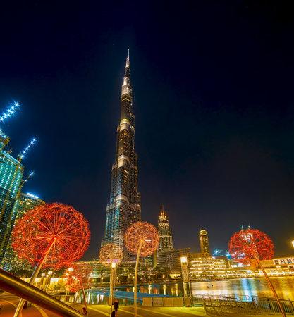 DUBAI, UAE - MARCH 3, 2020: The great view on Burj Khalifa tower and glowing colorful dandelions sculptures on Burj Park, on March 3 in Dubaiのeditorial素材