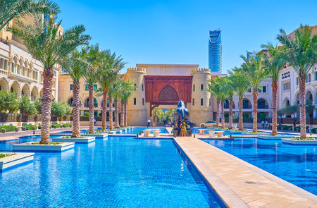 DUBAI, UAE - MARCH 3, 2020: THe narrow alley between pools leading to huge statue of the horse and the replica of medieval Gate in Old Town Island complex, on March 3 in Dubaiのeditorial素材