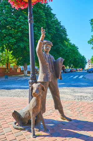 KAMIANETS, UKRAINE - JULY 14, 2021: The sculpture of a postboy with dog, located in the Polish Market square, on July 14 in Kamianetsのeditorial素材