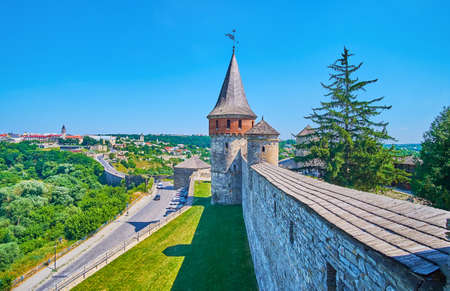 The top view of the stone rampart, Commandant's and Lanckoronska Towers, outer wall of Kamianets-Podilskyi Castle and the lush green trees in canyon of Smotrych River, Ukraineの写真素材