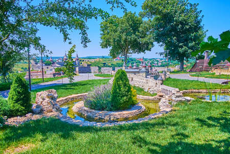 The lush green park of Museum of Miniatures with green lawn, tiny ponds, blooming lavender and small...
