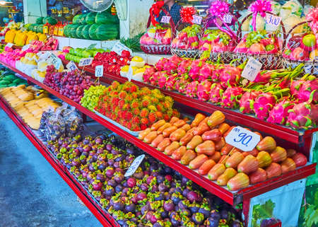 The stall's counter with wide range of tropic fruits - rose-apples, rambutans, dragon fruits, mangosteens, mango and others, Tanin Market, Chaing Mai, Thailandの写真素材