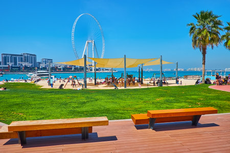 Relax on modern and comfortable JBR Marina beach, including green zone, sand coast, playgrounds, beach cafes, different attractions and great view on Ain Dubai Ferris Wheel and Bluewaters Island, Dubai, UAEのeditorial素材