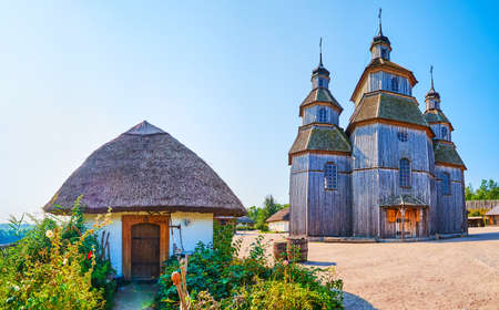 Panorama of Zaporozhian Sich scansen with small cossack houses, located around the tall wooden Orthodox church of Intercession, Khortytsia Island, Zaporizhzhia, Ukraineの写真素材