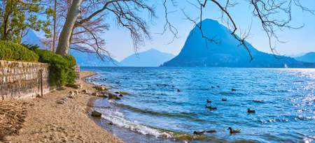 Panorama of the sandy shore of Lugano Lake in Parco Ciani of Lugano, Switzerlandの写真素材