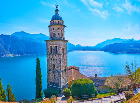 The picturesque Lugano Lake, surrounded with Alps and with tall bell towr of Santa Maria del Sasso Church in the foreground, Morcote, Switzerlandの写真素材