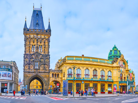 PRAGUE, CZECH REPUBLIC - MARCH 5, 2022: The tall Gothic Powder Gate and ornate Art Nouveau Municipal House (Smetana Hall) with green dome, moulding and mosaic panel, on March 5 in Pragueのeditorial素材