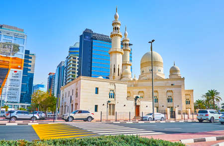 DUBAI, UAE - MARCH 1, 2020: The modern white Al Yaqub Mosque with carved domes and tall minarets, located on the busy street of Deira, on March 1 in Dubaiのeditorial素材