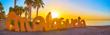 MALAGA, SPAIN - SEPTEMBER 29, 2019:  Panorama of Malagueta beach sign against the Coasta del Sol and sunrise sky, on September 29 in Malagaのeditorial素材