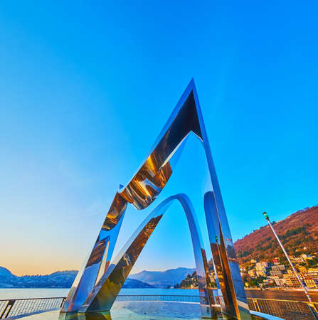 COMO, ITALY - MARCH 20, 2022: The modern Electric Life sculpture on Lake Como against the bright sunset sky, on March 20 in Comoのeditorial素材