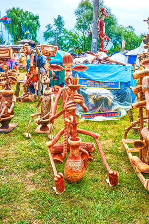 SOROCHYNTSI, UKRAINE - AUGUST 19, 2021: The wooden carved figures on the market on National Sorochynsky Fair, such as clothes, winter socks and blankets, on August 19 in Sorochyntsiのeditorial素材