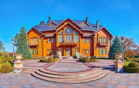 MEZHYHIRYA, UKRAINE - OCT 26, 2021: The facade of wooden Honka club house of Mezhyhirya Residence, surrounded with ornamental park, on Oct 26 in Mezhyhiryaのeditorial素材