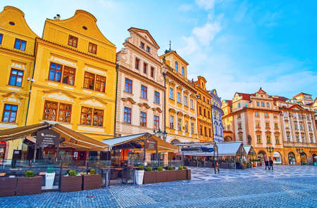 The colored historic facades of townhouses of Old Town Square with outdoor restaurants and bars in the foreground, Stare Mesto, Prague, Czech Republicの写真素材