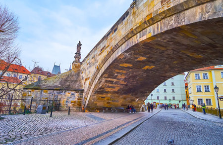 The old Na Kampe street runs under the medieval arched Charles Bridge, Mala Strana, Prague, Czech Republicの写真素材