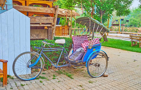 The vintage trishaw, parked at the small wooden bar on the bank of Pai River, Pai, Thailandの写真素材