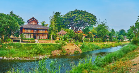 Panorama of Pai River, surrounded with tropical gardens, forests, tall grasses and wooden houses, Pai, Thailandの写真素材
